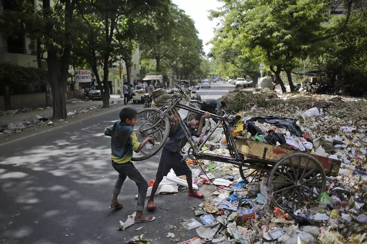 Young Indian garbage collectors unload waste at a roadside garbage dumping site overflowing with filth on World Day against Child Labor in New Delhi, India, Friday, June 12, 2015. Despite the country's rapid economic growth, child labor remains widespread in India, where an estimated 13 million children work, with laws meant to keep kids in school and out of the workplace routinely flouted. (AP Photo/Altaf Qadri)